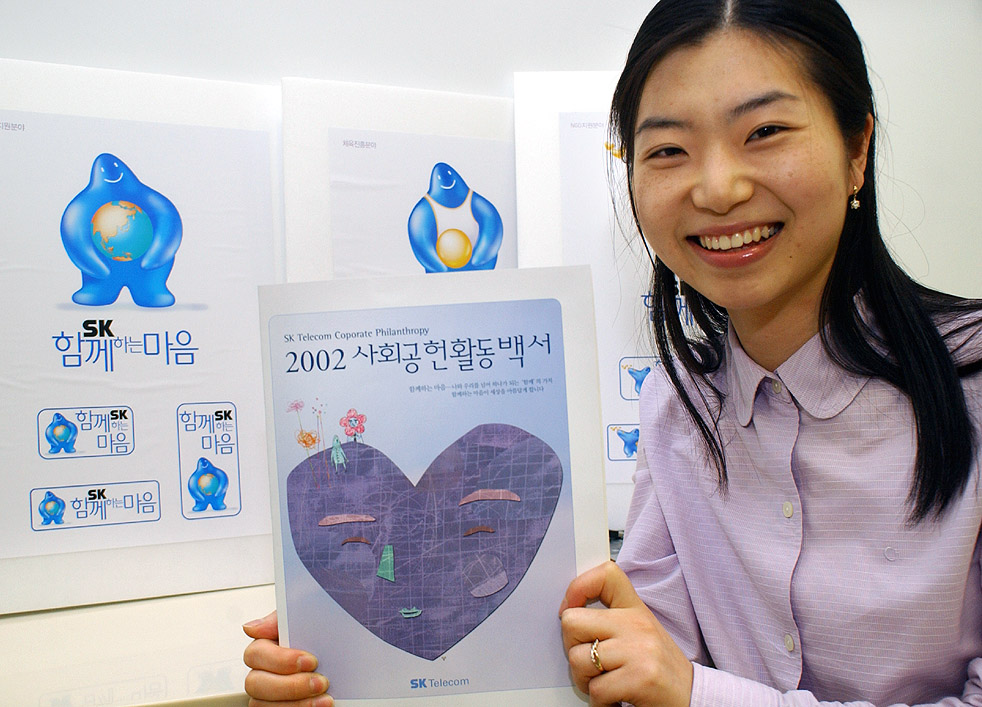 Through the `2002 SK Telecom Social Contribution Report` published on May 14, SK Telecom accomplished great achievements by carrying out social contribution activities. One of the visitors to SK Telecom branch office is shown reading the `2002 SK Telecom Social Contribution Report`.